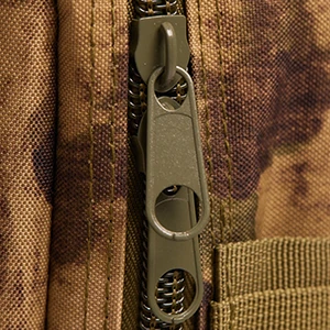 Close-up of a metallic zipper on a tactical backpack, showcasing its strength and durability.